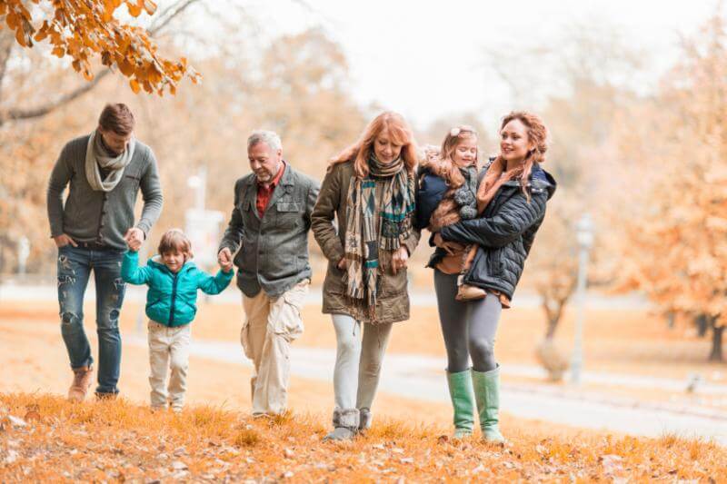 3 generations of a family walking together on a fall day